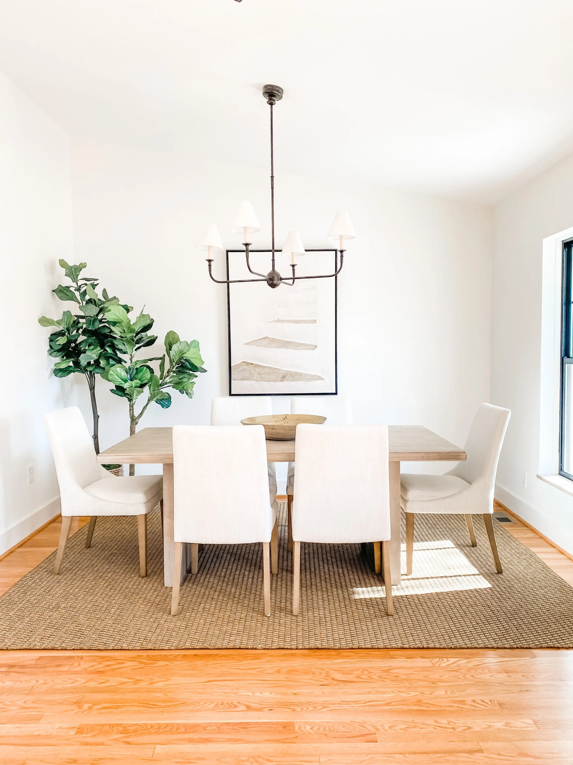 A serene dining room with greenery in the corner, adding a pop of greenery and a sense of calm.
