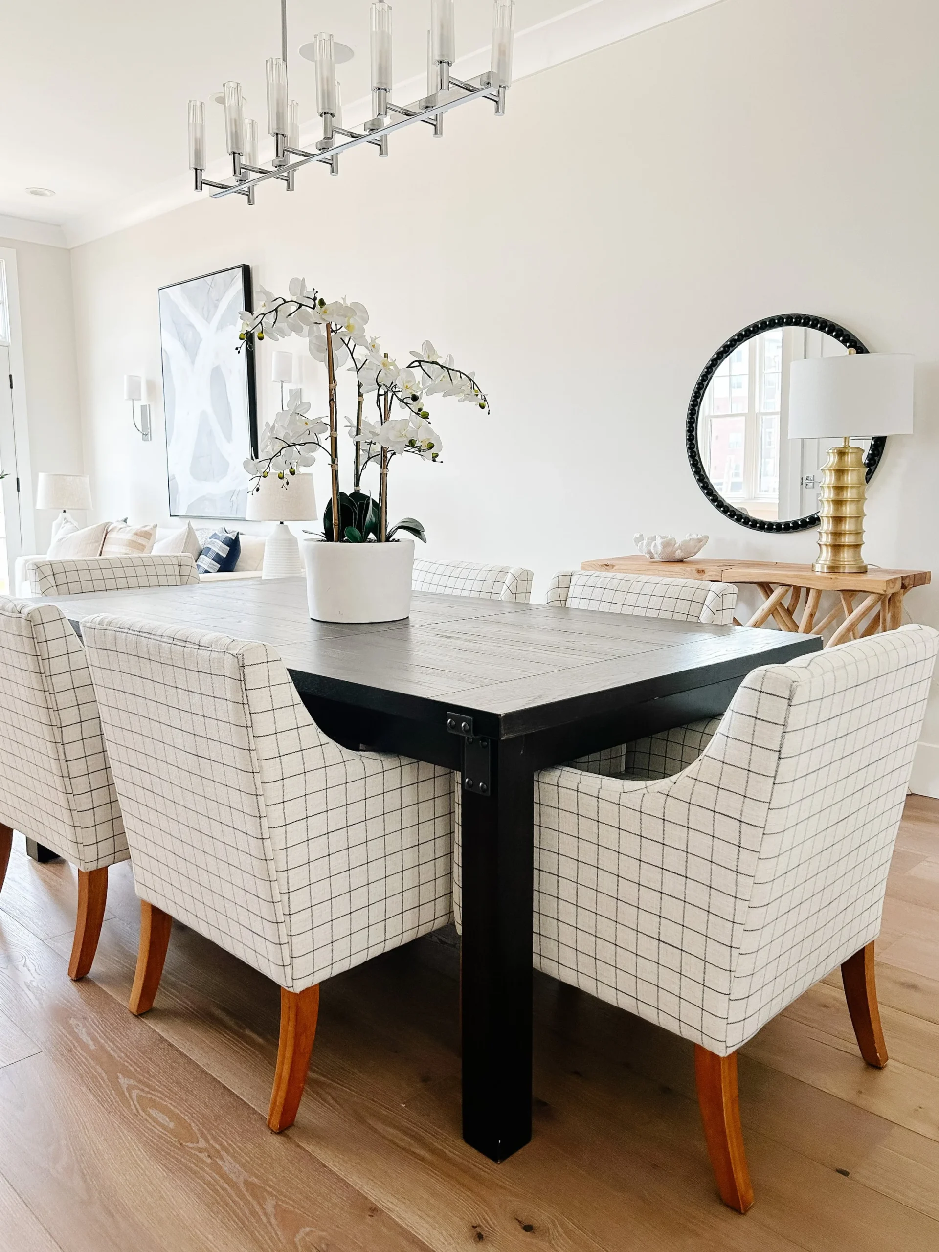 A natural-lit dining area enhanced by a statement plant, bringing life and color to the room's clean, contemporary look.