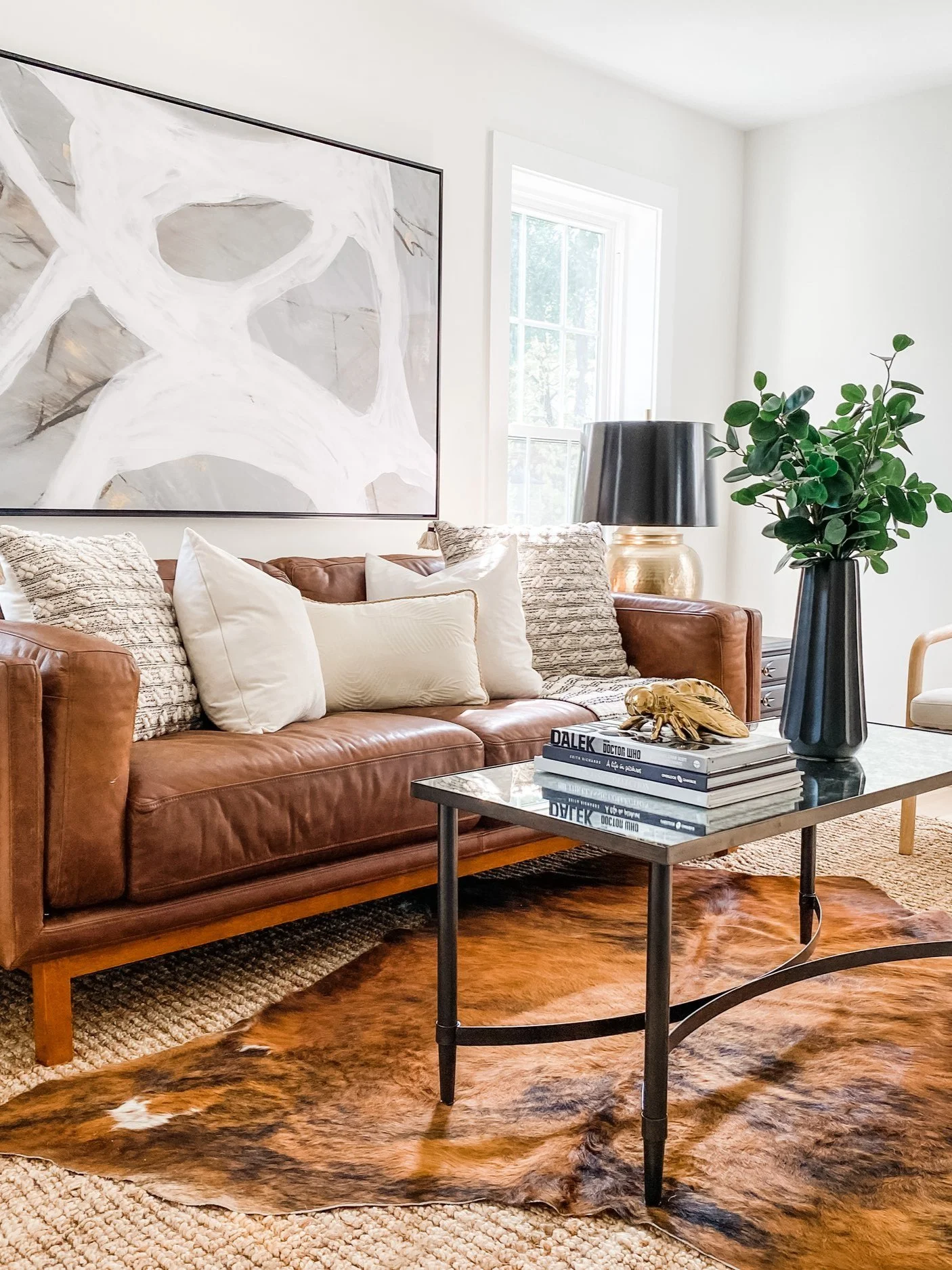 A cozy living featuring greenery, softening the minimalist style with a touch of nature